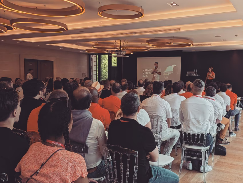 Collaborateurs assistant à une plénière lors de la convention annuelle du groupe en 2023 dans une salle moderne