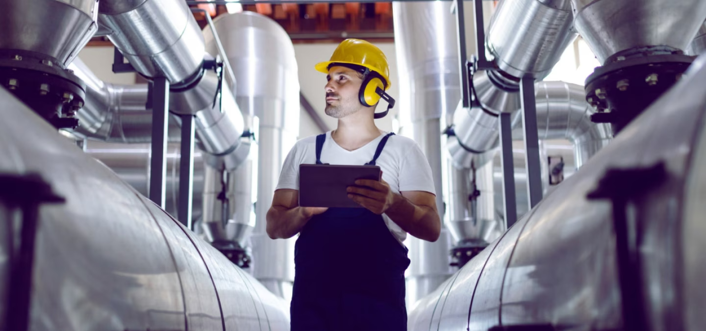 Technicien inspectant une usine avec une tablette numérique