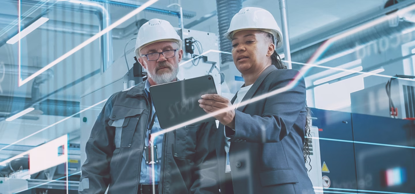 Ingénieurs industriels analysant des données de production sur tablette dans un environnement connecté