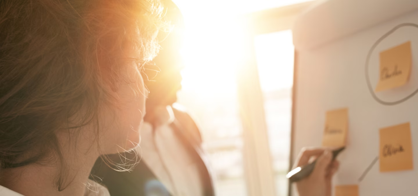 Réunion de travail avec organisation d’idées sur un paperboard à l’aide de post-its